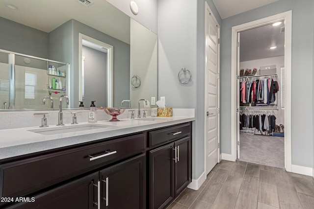 bathroom featuring vanity and a shower with door