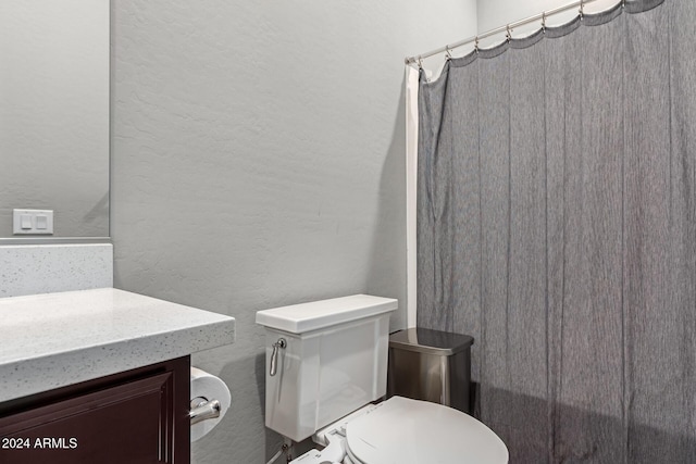 bathroom featuring a shower with shower curtain, vanity, and toilet