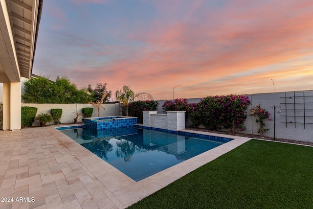 pool at dusk featuring an in ground hot tub