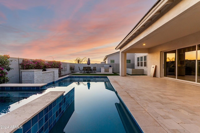 pool at dusk featuring a patio area