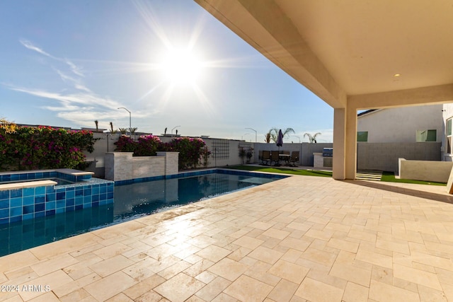 view of pool featuring a patio area and an in ground hot tub