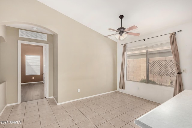 tiled spare room with ceiling fan