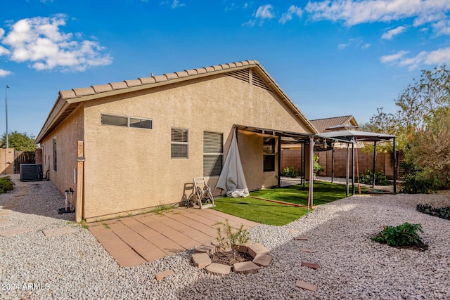 rear view of property with central AC unit, a gazebo, a yard, and a patio