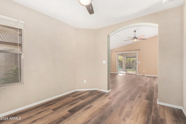 empty room featuring ceiling fan, dark hardwood / wood-style flooring, and vaulted ceiling