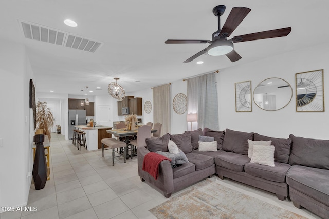 living room with recessed lighting, visible vents, light tile patterned flooring, and ceiling fan with notable chandelier