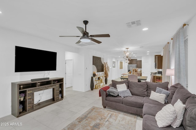 living area featuring light tile patterned floors, visible vents, baseboards, recessed lighting, and ceiling fan with notable chandelier