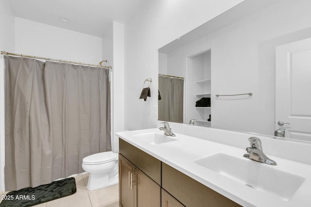 bathroom with tile patterned flooring, double vanity, toilet, and a sink