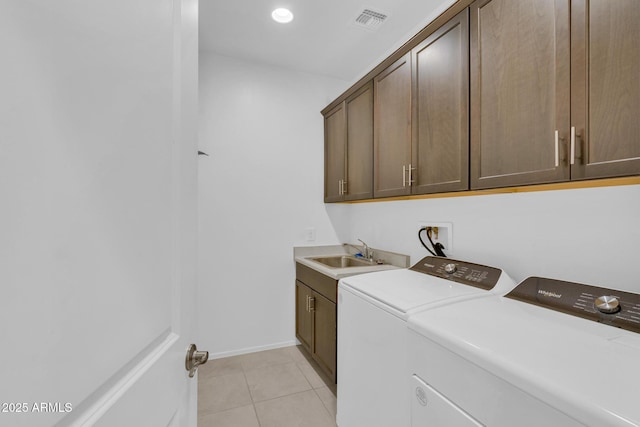 laundry room with a sink, washer and dryer, cabinet space, light tile patterned flooring, and baseboards