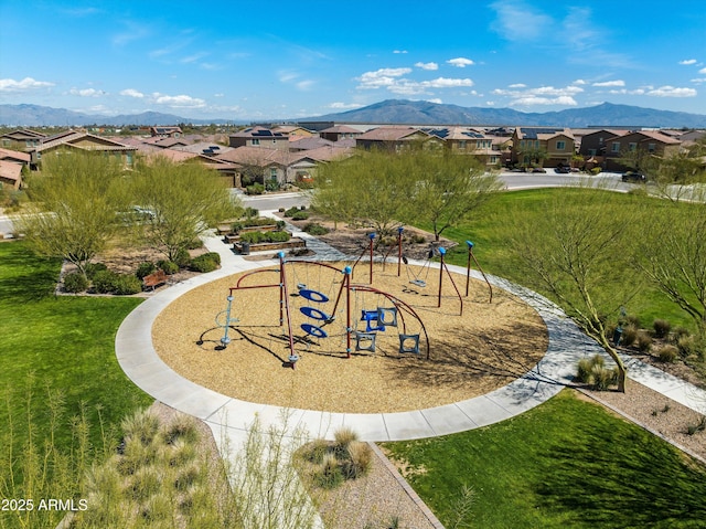 view of property's community with a mountain view, a residential view, a lawn, and playground community