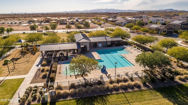 pool featuring a patio area, a mountain view, fence, and a residential view