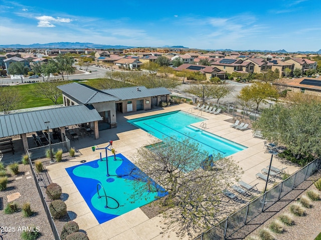 community pool featuring a patio area, a residential view, and fence