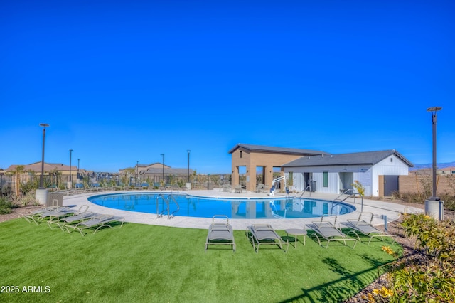 community pool with a yard, fence, and a patio area