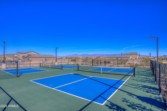 view of sport court featuring community basketball court, a mountain view, and fence