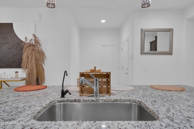 kitchen with light stone countertops and a sink