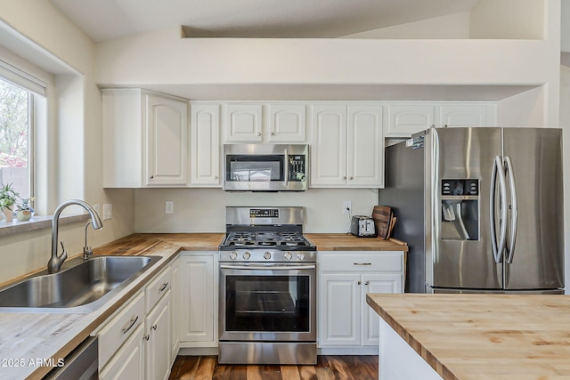 kitchen featuring a sink, dark wood-style floors, white cabinetry, appliances with stainless steel finishes, and butcher block counters