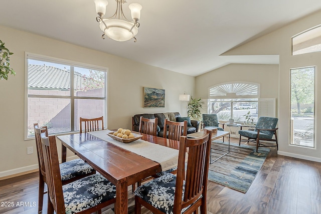 dining area featuring baseboards, lofted ceiling, an inviting chandelier, and wood finished floors