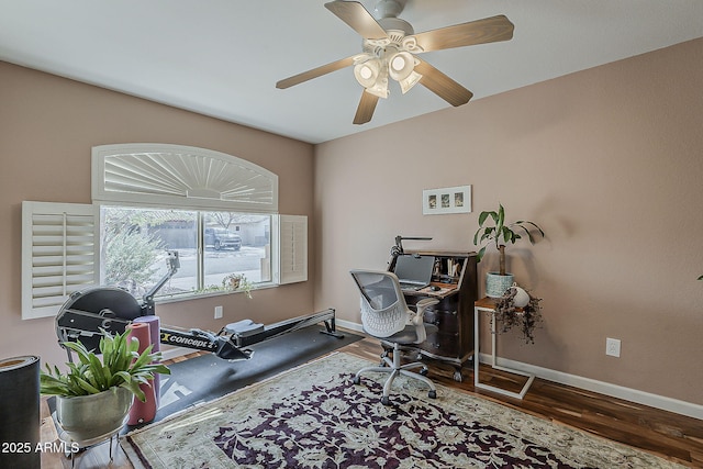 office area with a ceiling fan, baseboards, and wood finished floors