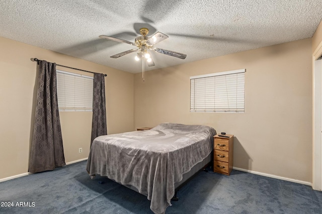 carpeted bedroom with ceiling fan and a textured ceiling