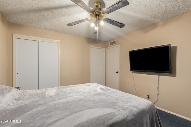 unfurnished bedroom with carpet flooring, ceiling fan, a closet, and a textured ceiling