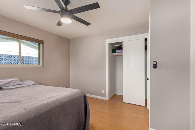 bedroom with a closet, light hardwood / wood-style flooring, and ceiling fan