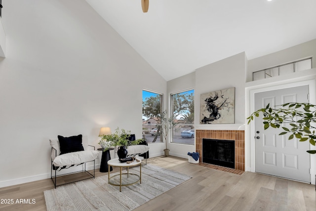 1717 E Union Hills Dr Unit 1033, Phoenix, AZ 85024 - living area with high vaulted ceiling, wood finished floors, a tile fireplace, baseboards, and a ceiling fan