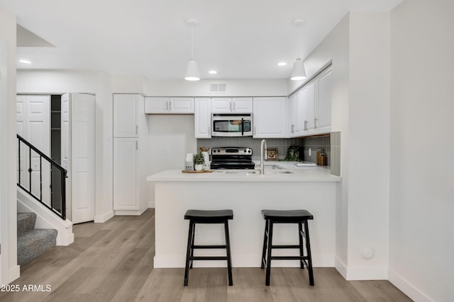 1717 E Union Hills Dr Unit 1033, Phoenix, AZ 85024 - kitchen with appliances with stainless steel finishes, a peninsula, white cabinetry, light countertops, and recessed lighting