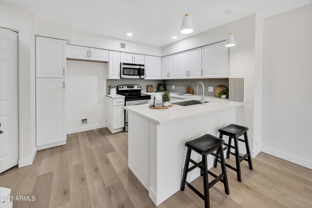 1717 E Union Hills Dr Unit 1033, Phoenix, AZ 85024 - kitchen with appliances with stainless steel finishes, a sink, a peninsula, light wood-style floors, and recessed lighting