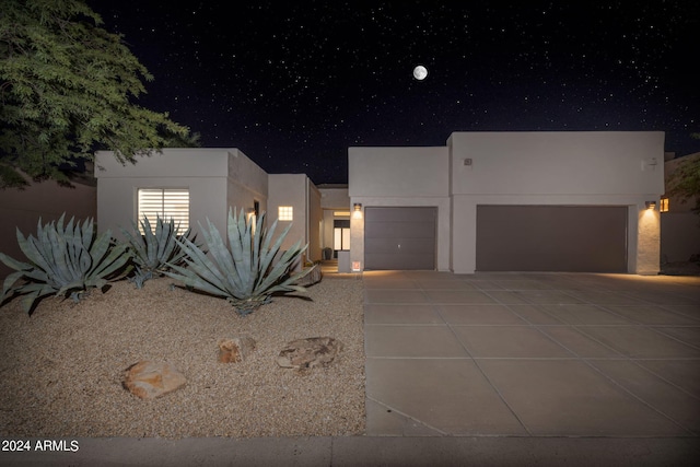 view of front of home featuring a garage, driveway, and stucco siding