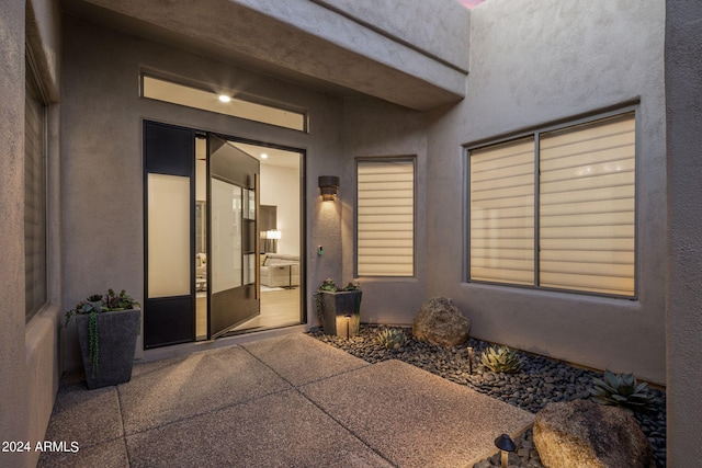 doorway to property with stucco siding and a patio area