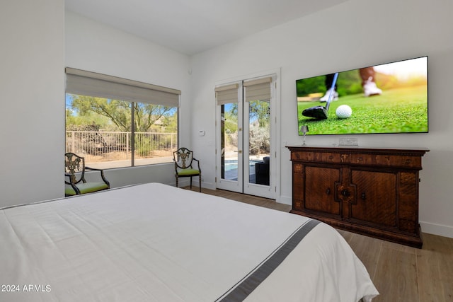 bedroom with access to outside and hardwood / wood-style floors