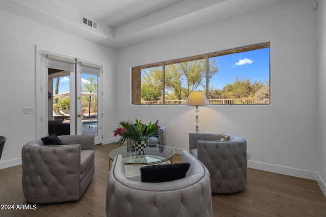 living area with wood finished floors, baseboards, and visible vents
