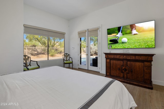 bedroom with baseboards, access to outside, and wood finished floors