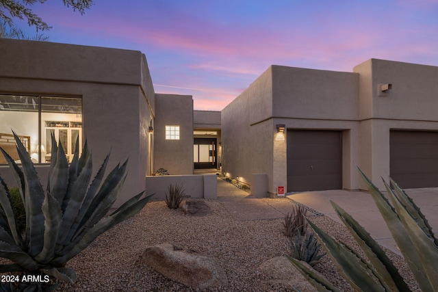 view of front of home featuring concrete driveway, stucco siding, and an attached garage