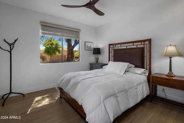 bedroom featuring baseboards, wood finished floors, and a ceiling fan