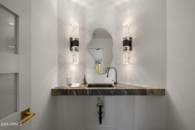 bathroom with a textured wall and a sink