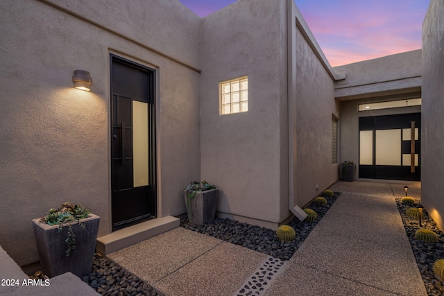 entrance to property with stucco siding