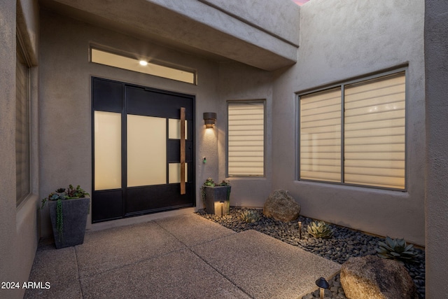 entrance to property featuring stucco siding