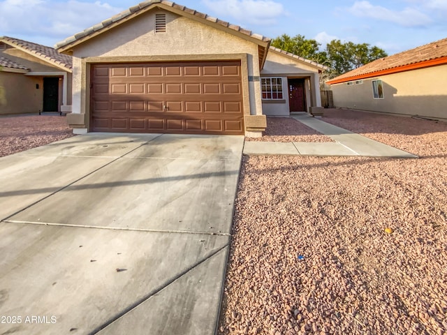 single story home featuring a garage, driveway, a tiled roof, and stucco siding