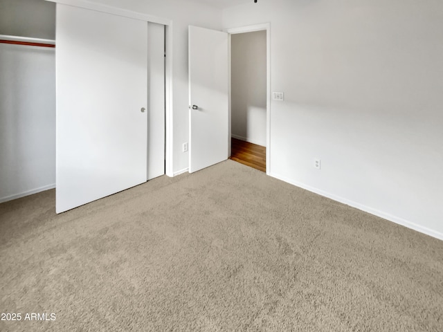 unfurnished bedroom featuring a closet, carpet flooring, and baseboards