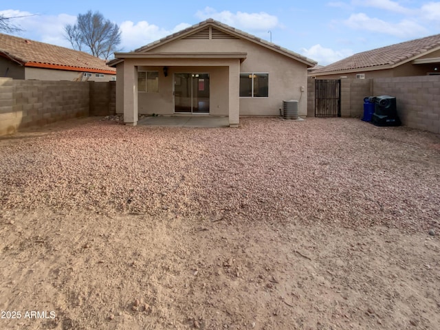 back of property featuring a patio, central AC unit, a fenced backyard, a gate, and stucco siding