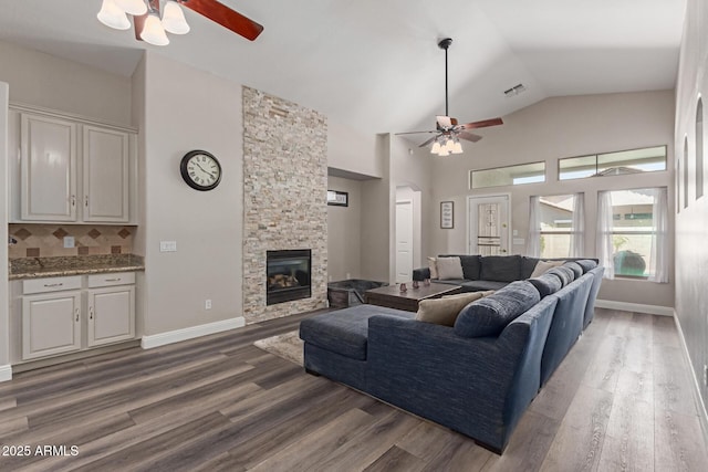 3580 E Kesler Ln, Gilbert, AZ 85295 - living area featuring a ceiling fan, a stone fireplace, visible vents, arched walkways, and wood finished floors