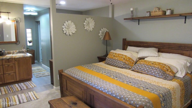 bedroom with sink and light colored carpet