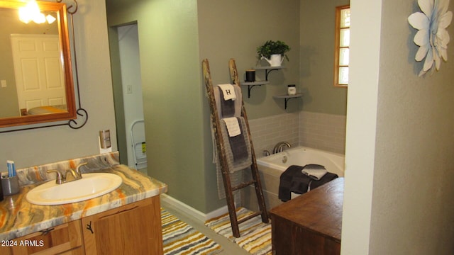 bathroom featuring tiled bath and vanity