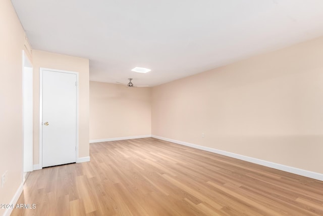 empty room with ceiling fan and light hardwood / wood-style flooring