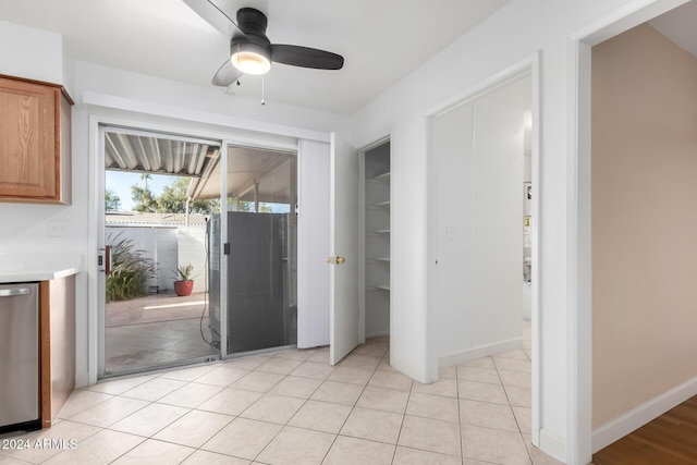 doorway featuring ceiling fan and light tile patterned floors