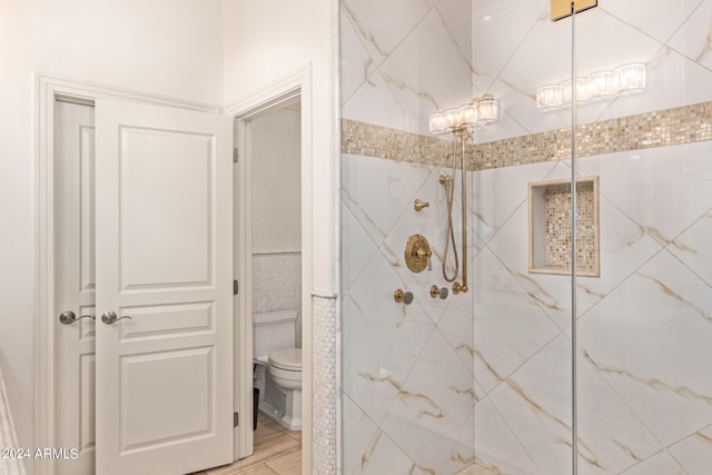 bathroom featuring a tile shower and toilet