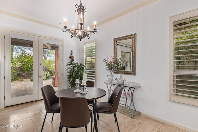 dining area featuring light wood-type flooring, ornamental molding, french doors, and a notable chandelier