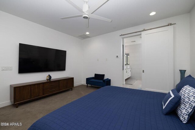 carpeted bedroom featuring a barn door, ensuite bathroom, visible vents, baseboards, and recessed lighting