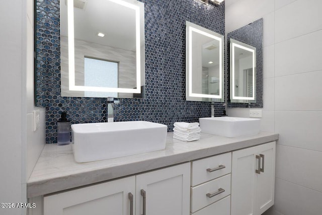 bathroom with tile walls, tasteful backsplash, and a sink