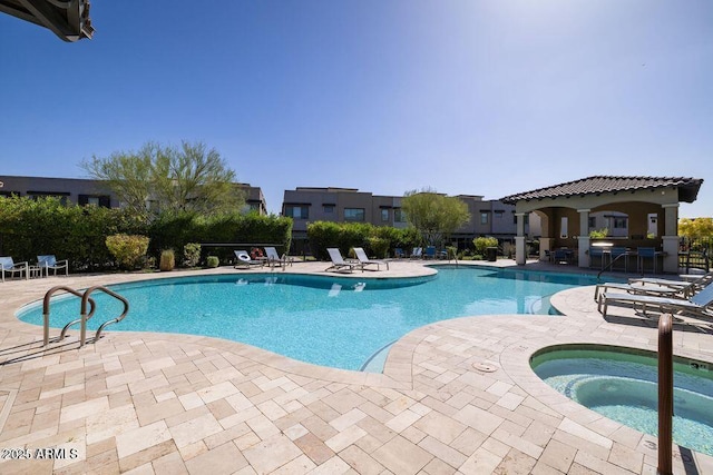 community pool featuring a patio area and a hot tub